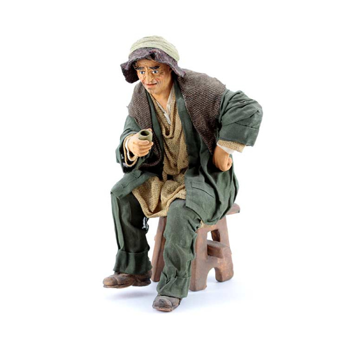 Uomo seduto su sgabello con bicchiere in terracotta vestita 30 cm